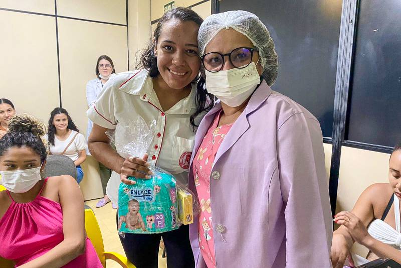 Enfermeira Janayna e participante durante entrega de brindes