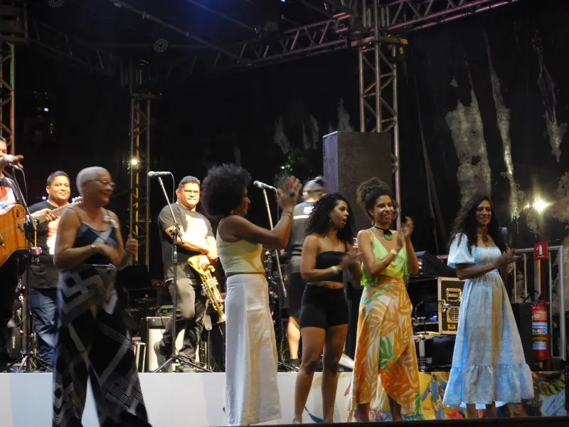 Monalisa (saia laranja) e Márcia Melo (vestido azul) no palco.